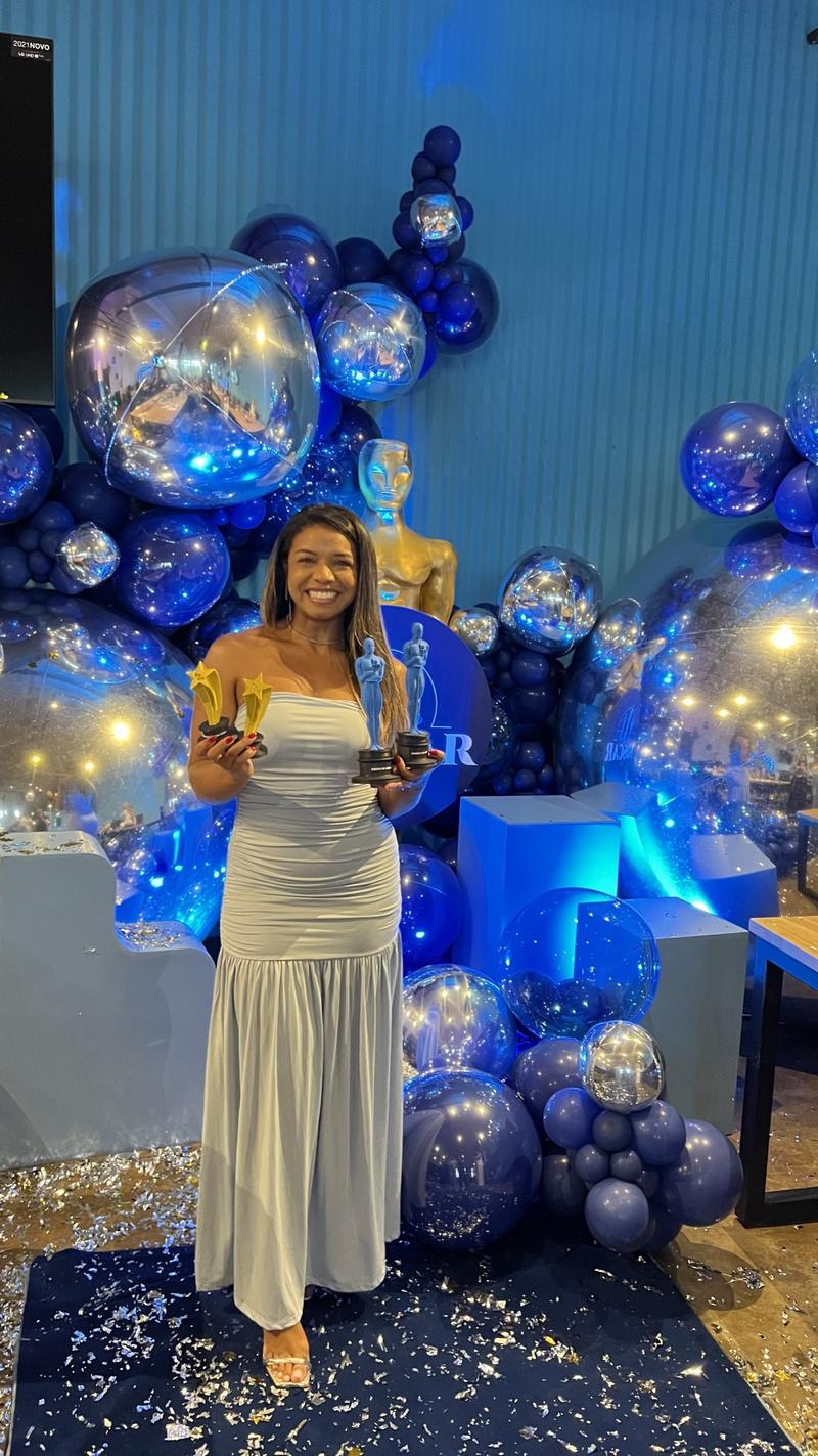 Pollyanne Martins segurando os três troféus FOSCAR